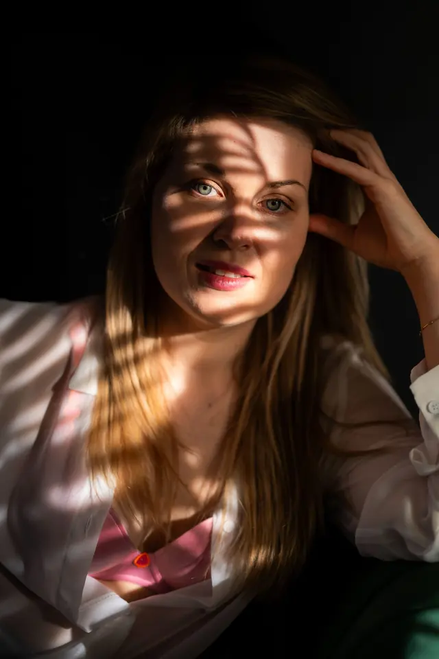 Portret van een vrouw met strepen daglicht over haar gezicht
