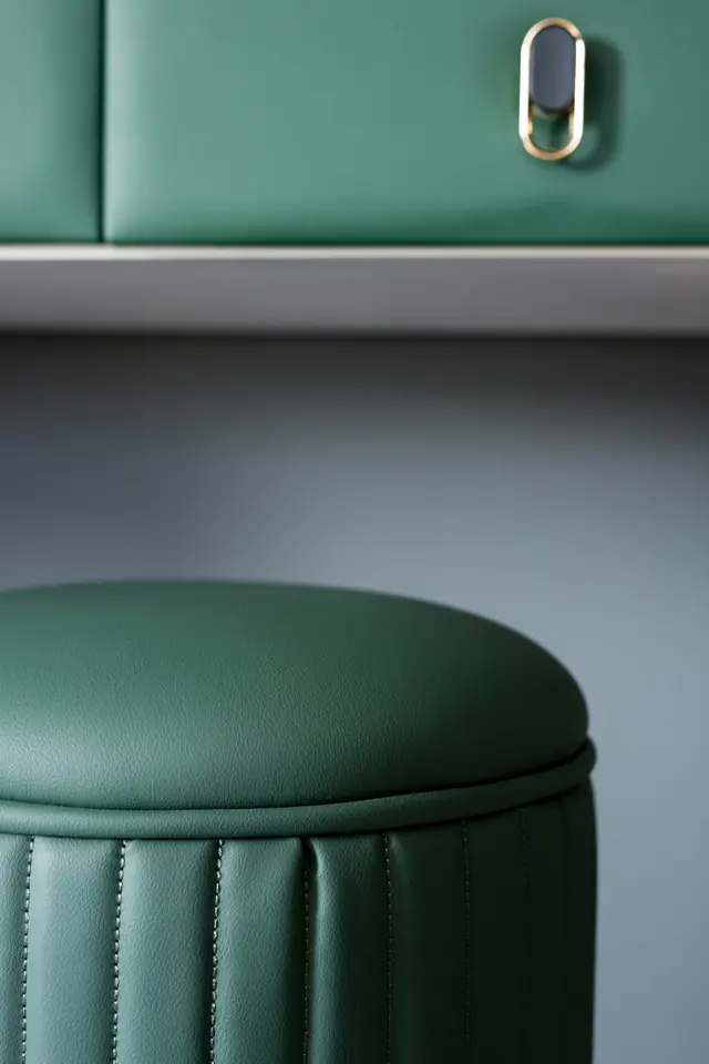 Groene fluwelen poef voor een groene kast met gouden greep